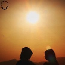 Silhouette of a man and woman against an orange sky