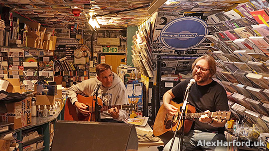 Hagop and Wojtek sat playing acoustic guitars. The record store walls and ceiling are covered in music releases and music posters. My kind of place!